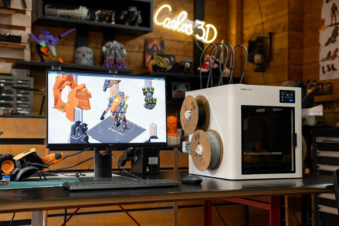3D printer beside a computer displaying a digital model on a desk