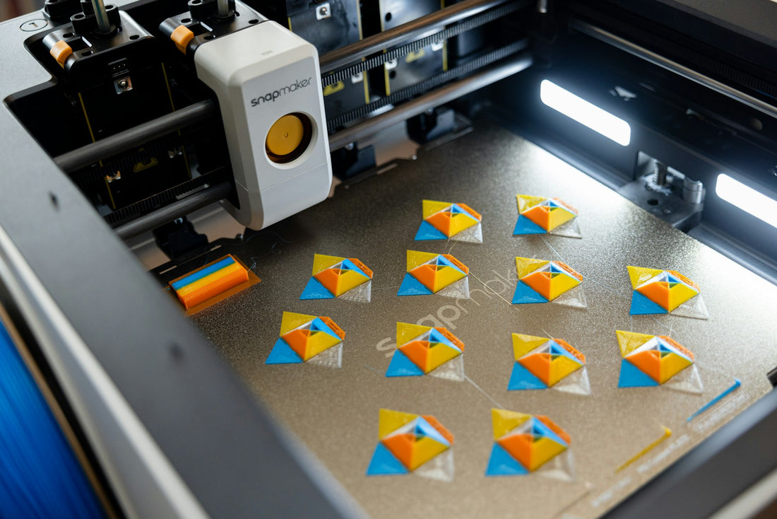 A 3D printer creating colourful geometric shapes on a build plate